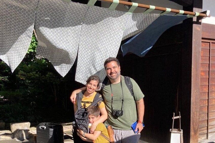 A person with a backpack standing in front of a wooden structure, possibly a shed or garage, with a child in a yellow shirt. 5