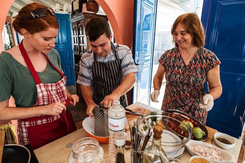 Trois personnes préparent un repas dans une cuisine, avec divers ingrédients et ustensiles disposés sur le plan de travail. 5