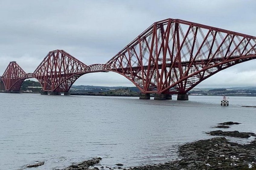 Un puente de acero rojo que cruza un cuerpo de agua. 5