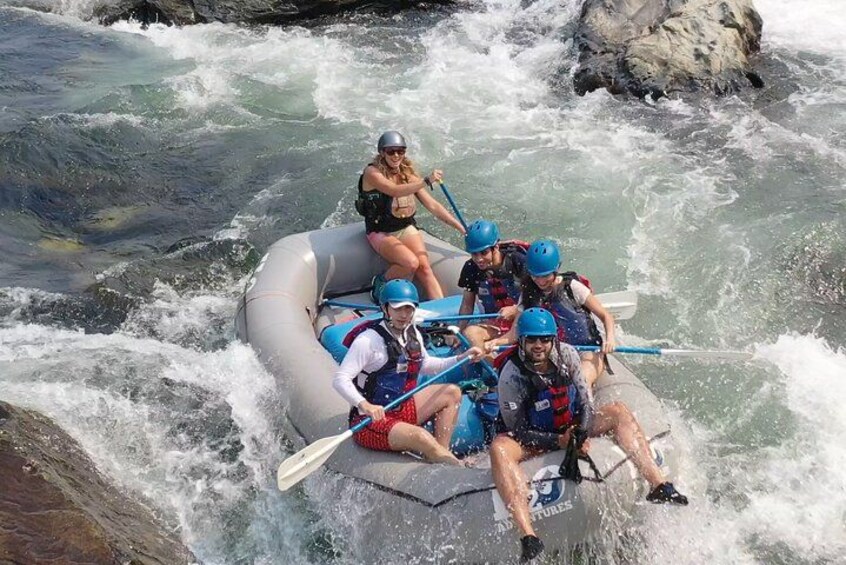 Un grupo de personas haciendo rafting en un río con rápidos. 1