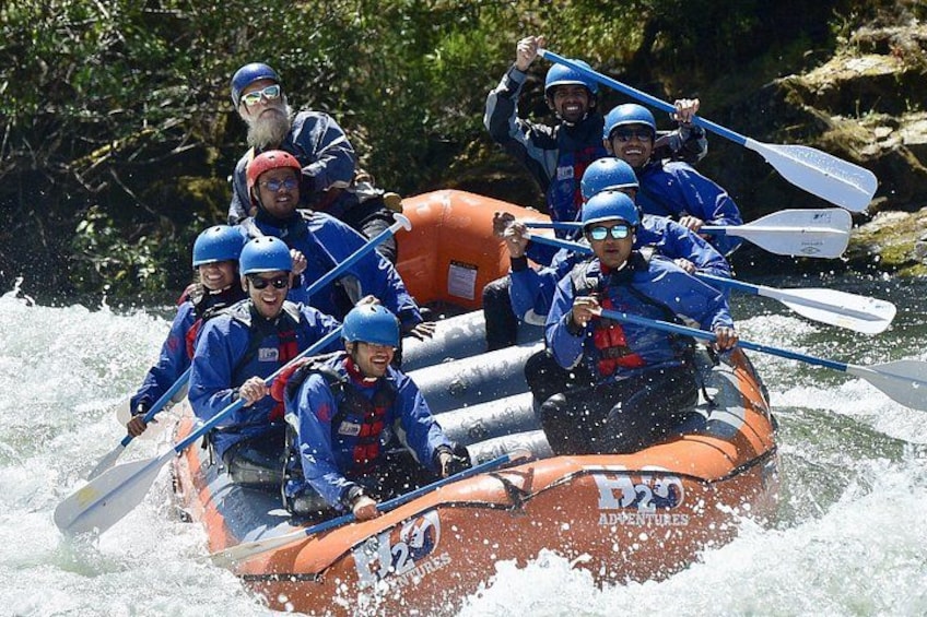 A group of people in a raft navigating a river. 3