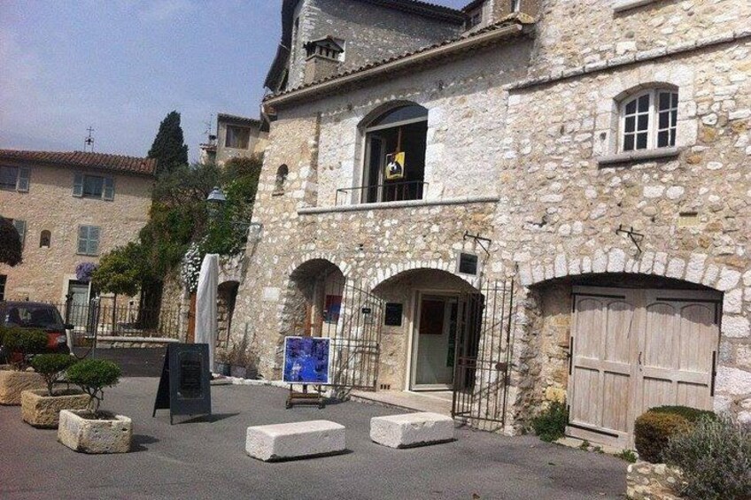 Un edificio in pietra con portali ad arco e una porta in legno. 2