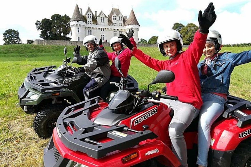 Three people on ATVs in front of a castle. 2