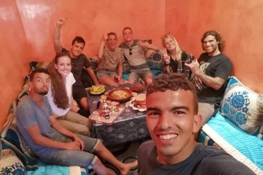 Un grupo de personas sentadas en un sofá con una mesa de comida frente a ellas. 3