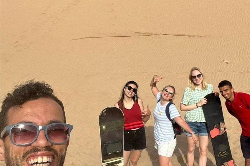 Un grupo de personas con tablas de snowboard en un paisaje desértico. 2