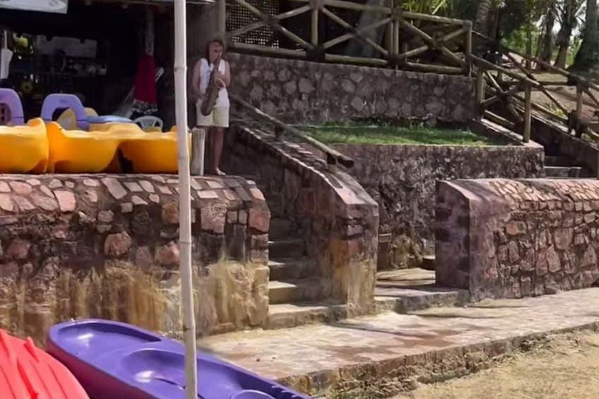 A water park with a stone wall, a wooden staircase, and colorful water slides. 2