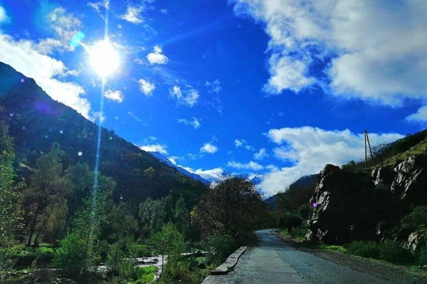 A mountain road with a clear sky and sunlight. 1