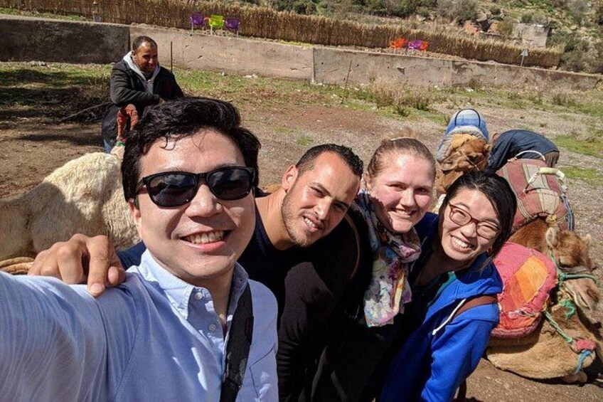 A group of people with a camel in a rural setting. 5