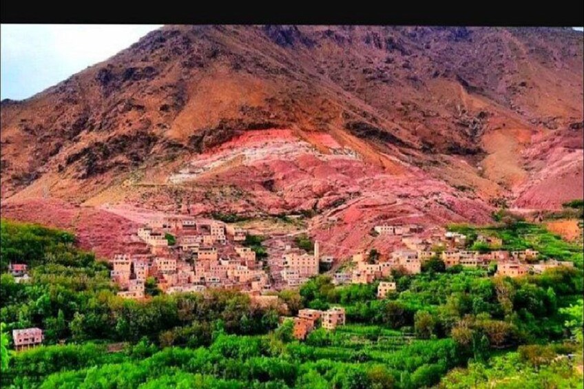 A village nestled in a valley with terraced fields and a mountainous backdrop. 4