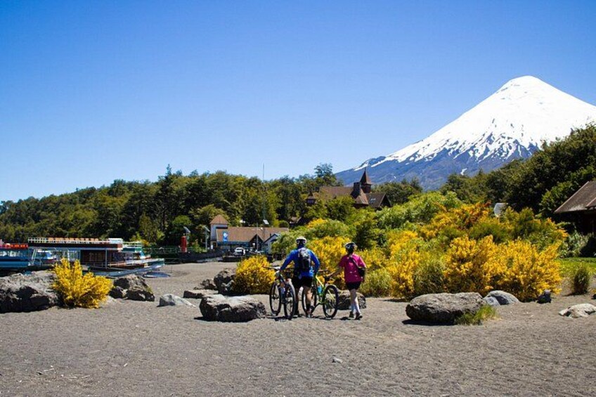 Two cyclists on a dirt path with a mountain in the background. 3