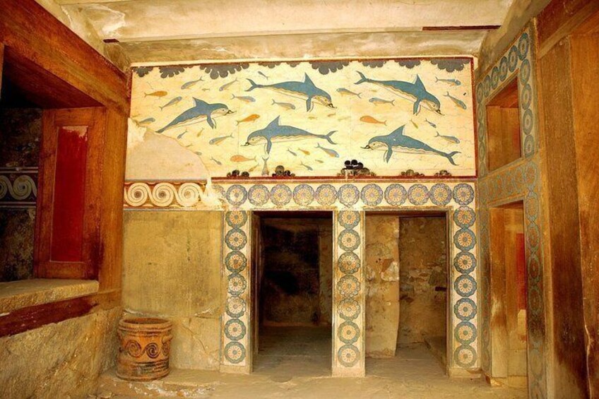 A room with a wall mural of dolphins, a tiled fireplace, and a wooden door. 2