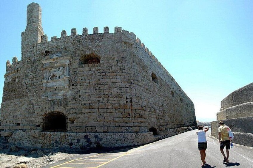 A historic stone fortress with battlements, a large arched entrance, and a prominent tower. 3