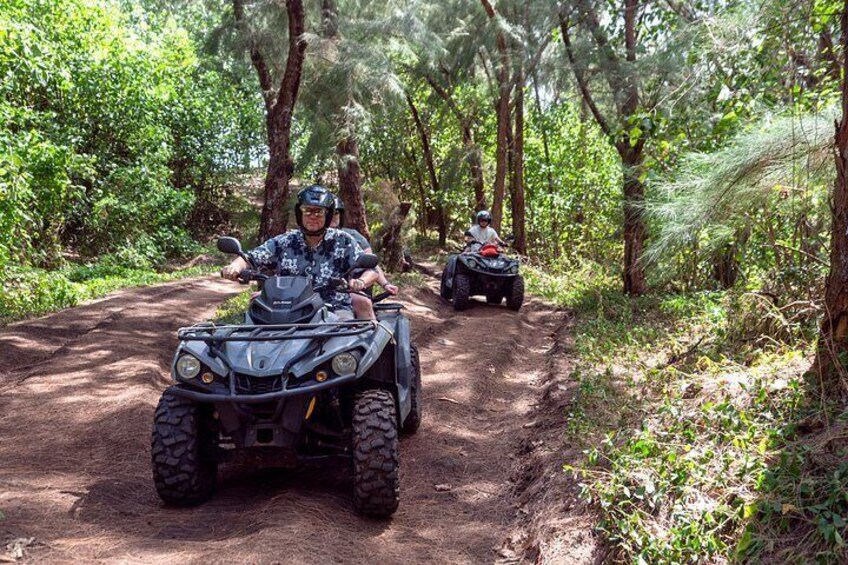 Two ATVs on a dirt path in a forested area. 5