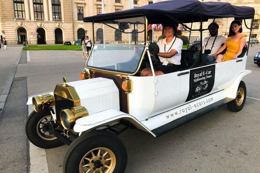 Een oldtimer met gouden accenten geparkeerd op een straat. 4