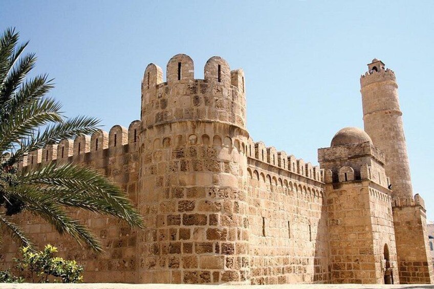 Un'antica fortezza in pietra con mura merlate e una torre imponente. 3