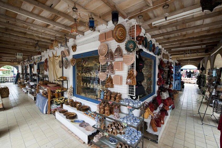 Una bancarella di mercato con ceramiche e tessuti assortiti. 5