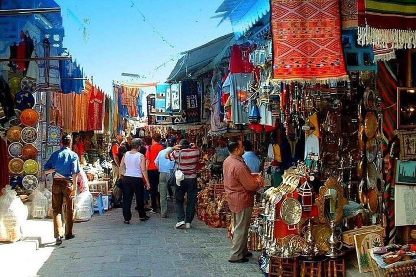 Un mercato vivace con persone che curiosano e venditori che offrono prodotti. 4