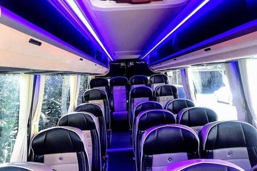 A train interior with rows of seats and overhead luggage compartments. 2