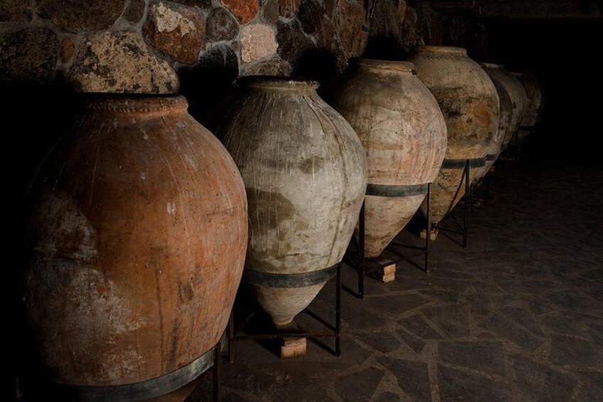 Large ceramic pots lined up against a stone wall. 3