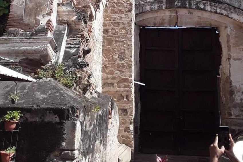A stone building with a large arched doorway and a staircase leading up to it. 4