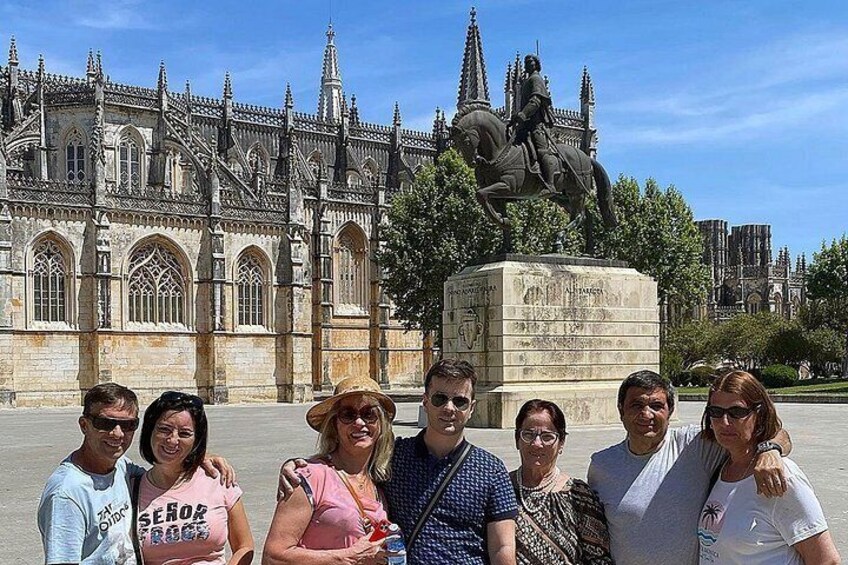A group of people in front of a Gothic-style cathedral with a statue of a man on horseback. 5