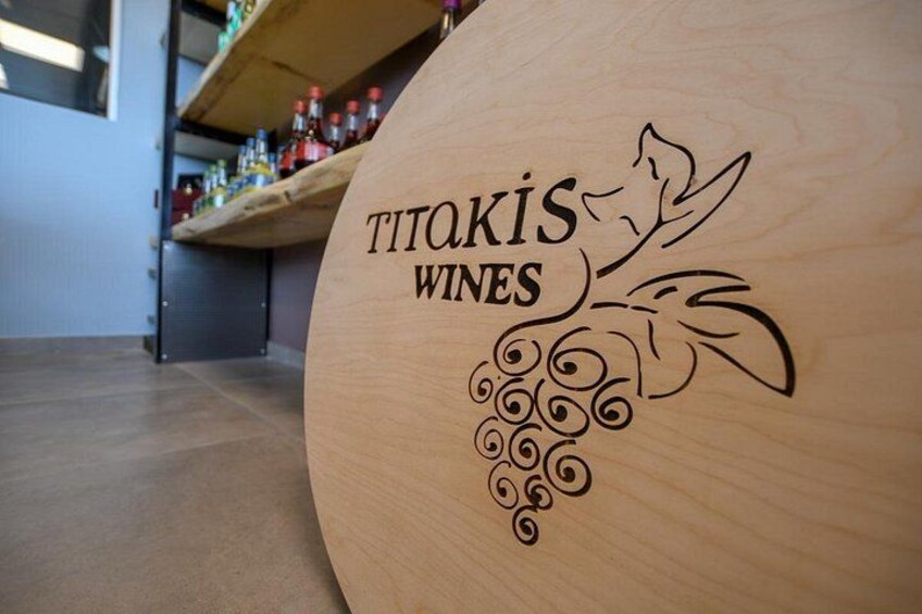 Un barril de madera con el texto 'TITAKIS WINES' y un diseño de vid. 3