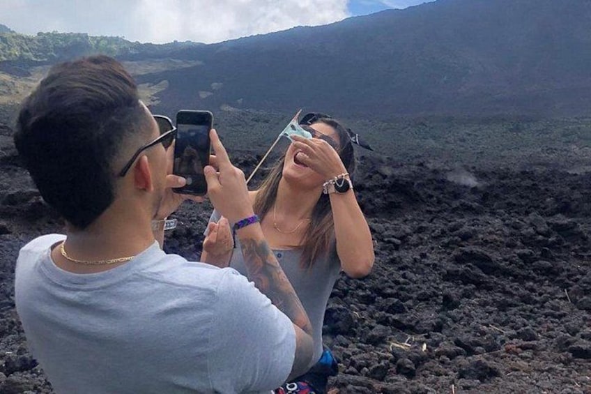 Dos personas fotografiando un paisaje volcánico. 1