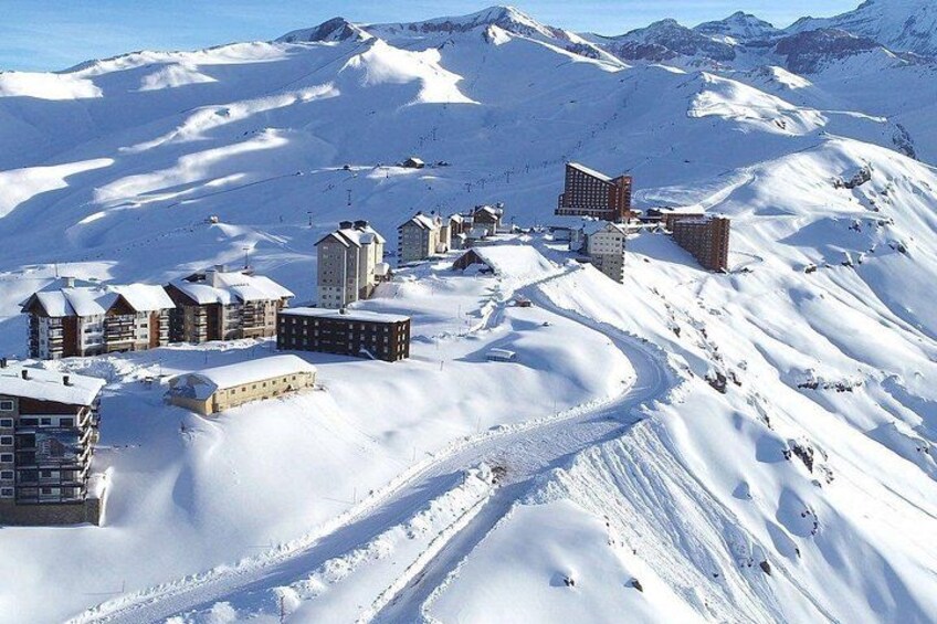 A snow-covered mountain town with buildings and ski slopes. 3