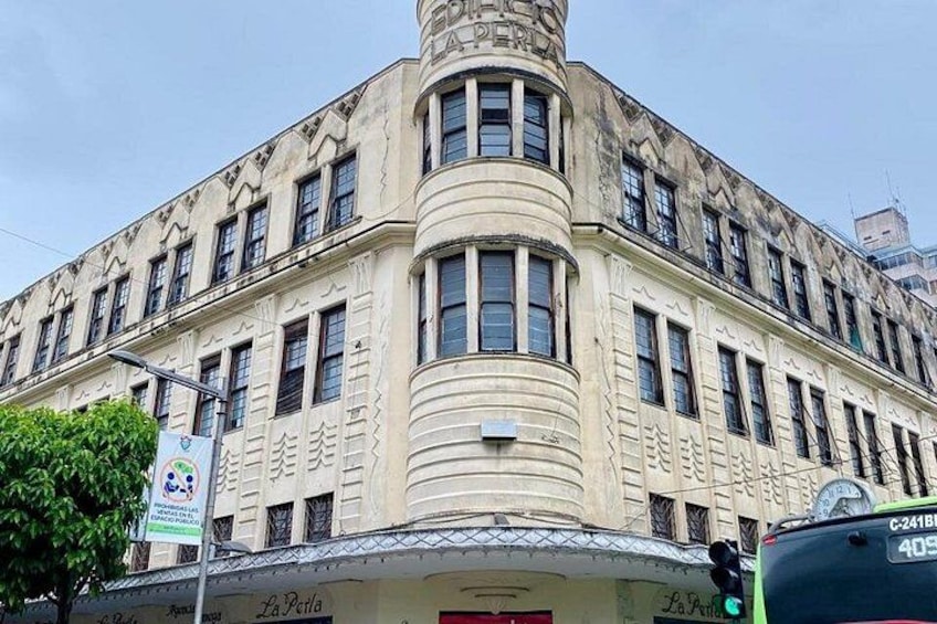 Ein historisches Gebäude mit einer geschwungenen Fassade, zahlreichen Fenstern und einer Turuhr an der Ecke. 4