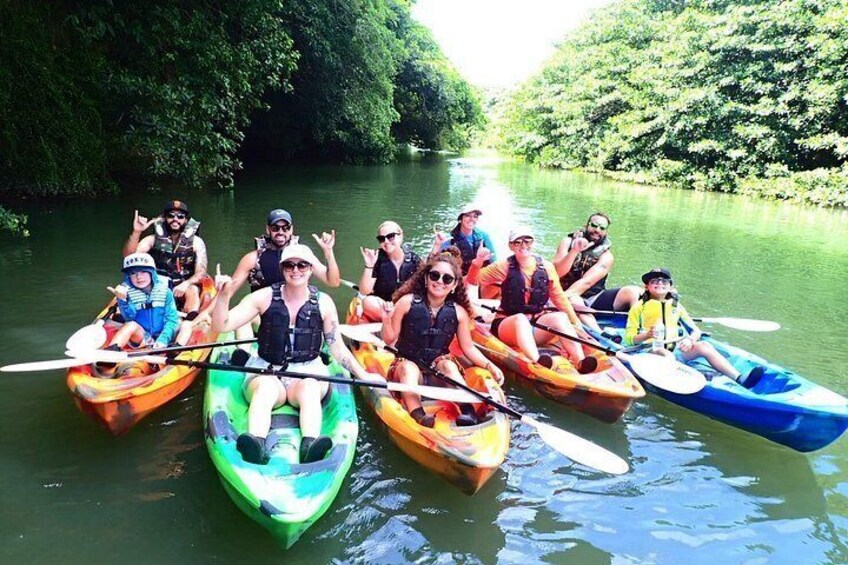 Un gruppo di persone in kayak colorati su un fiume circondato da vegetazione lussureggiante. 2