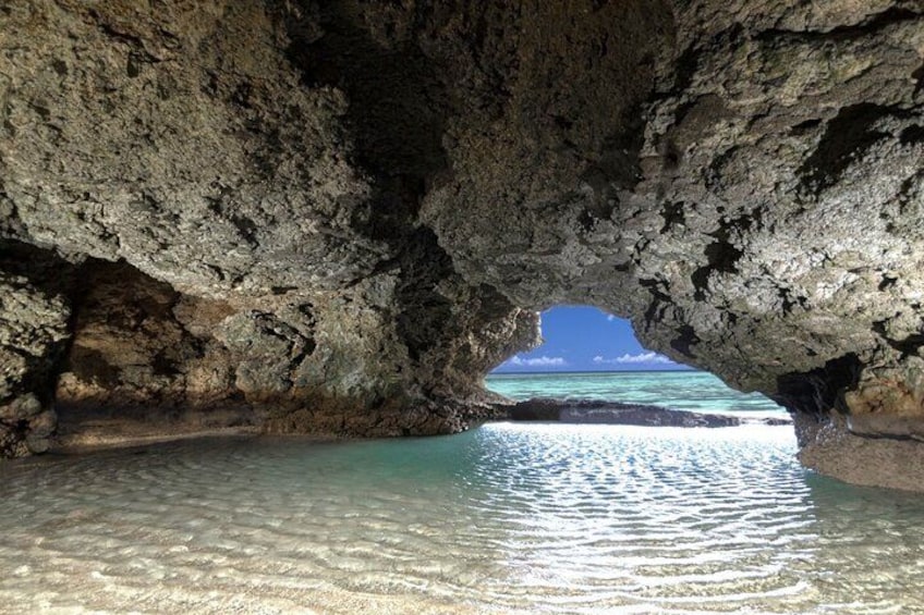 A cave opening to a clear turquoise sea. 2
