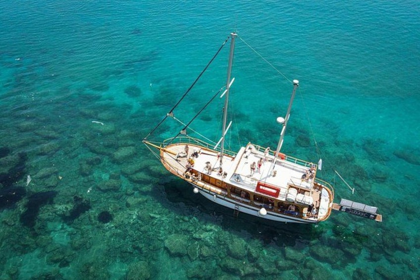 A boat floating on clear turquoise water. 1
