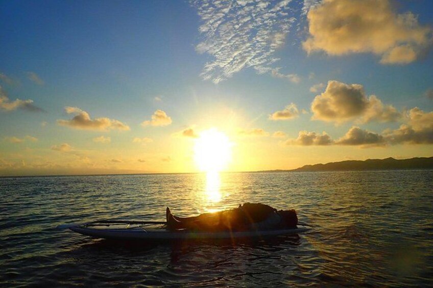 A boat on calm water with the sun setting in the background. 5