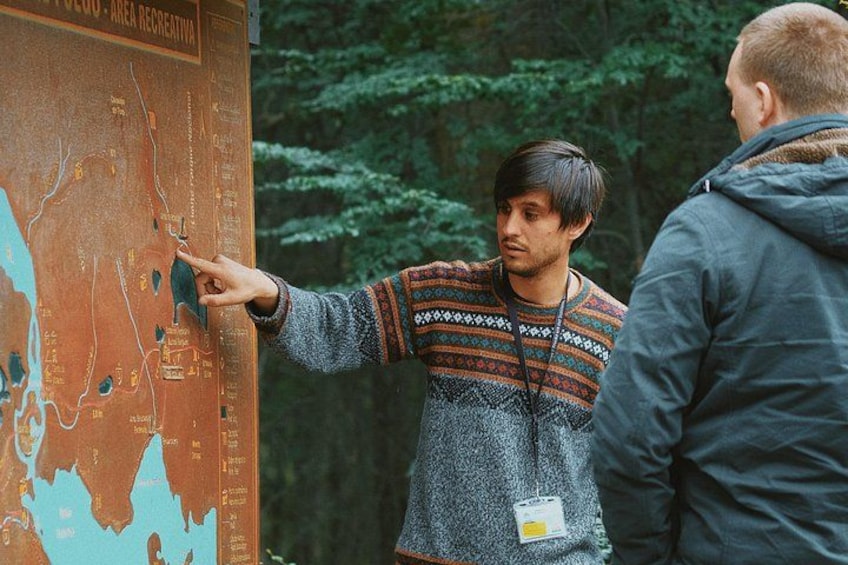 A person pointing at a map with a forest background. 4