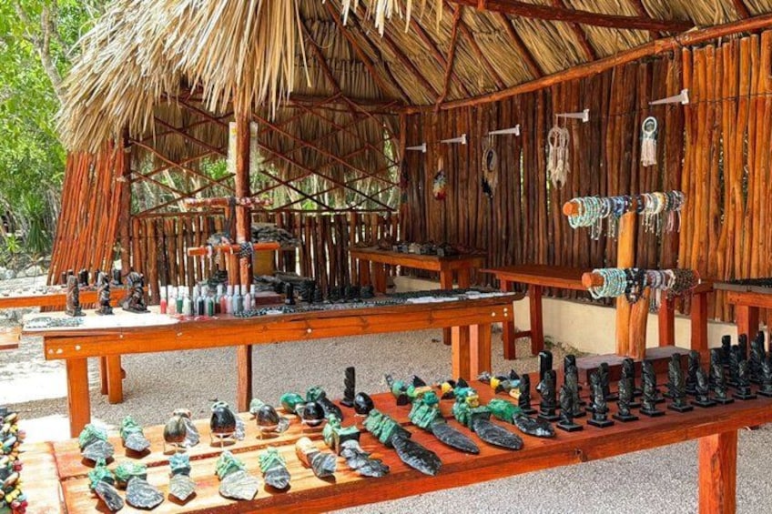 A wooden structure with a thatched roof, displaying various items like figurines and jewelry. 5