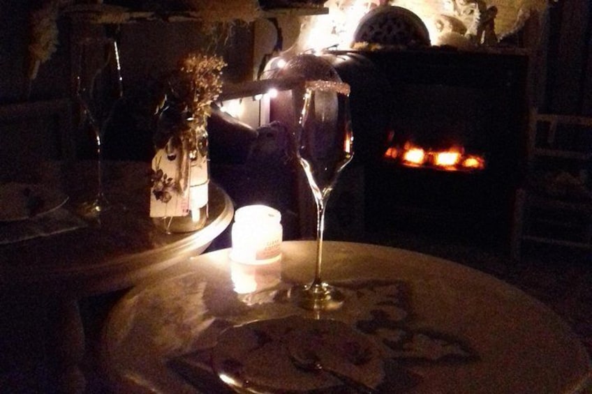 A table with a candle, a glass, and a plate with food remnants. 2