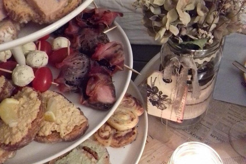 A variety of food items on plates, including skewers, bread, and a jar with a plant. 5
