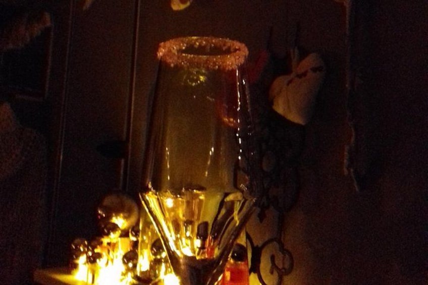 A candle with a decorative holder, a wall-mounted light fixture, and a small decorative item on the wall. 3