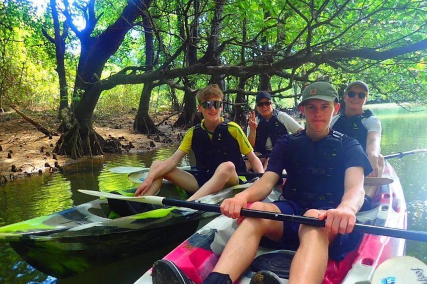People in a boat on a river surrounded by trees. 4