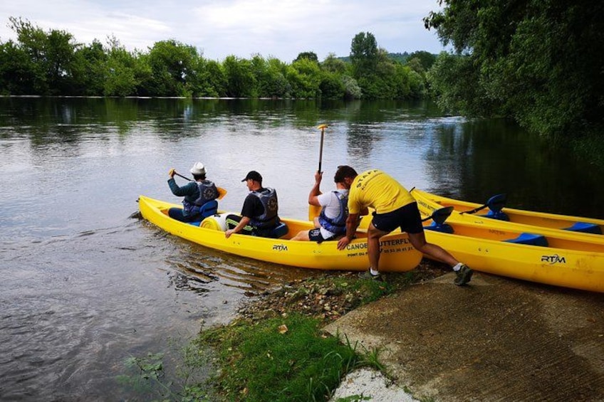 A river with kayaks and people preparing to paddle. 1