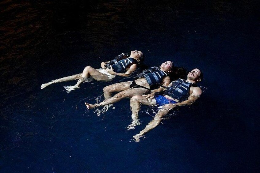 Three people floating on water, wearing life jackets. 5