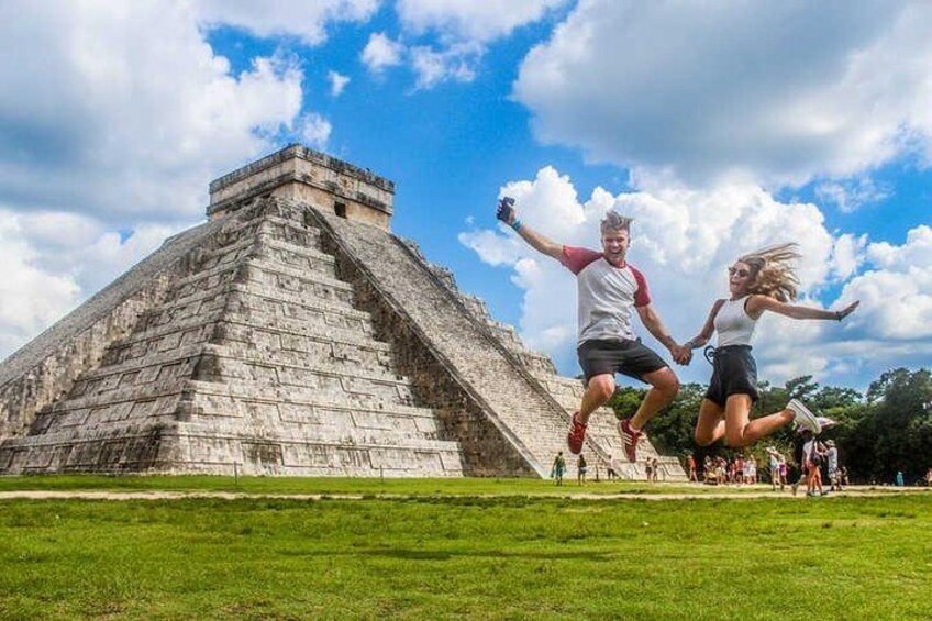 Une grande pyramide, des gens qui sautent et un champ d’herbe. 2
