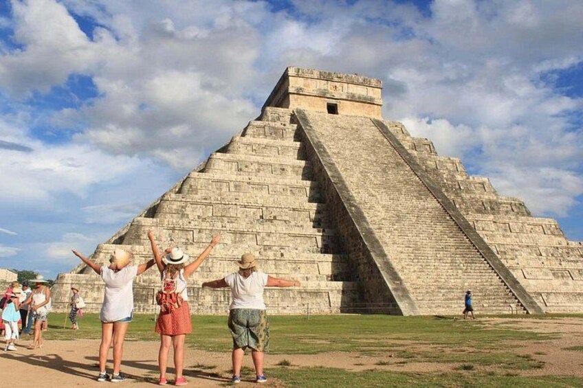 A large pyramid with tourists standing in front of it. 1