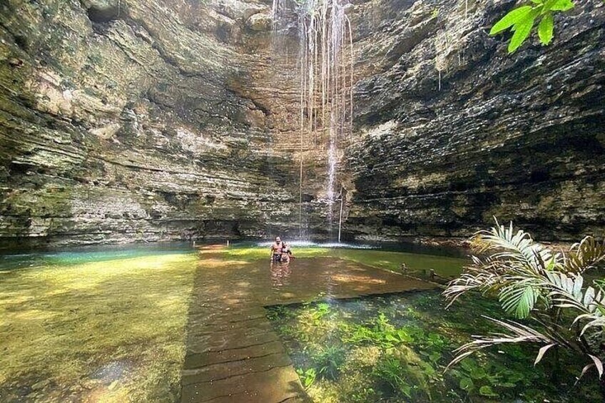 A waterfall in a cave with a person standing in the water. 3