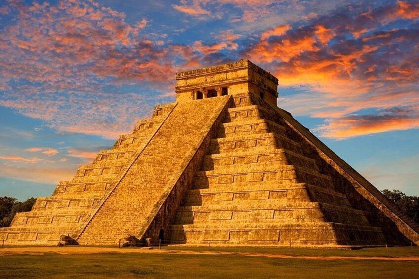 Eine große pyramidenförmige Struktur mit flacher Spitze, umgeben von einer grünen Wiese. 3