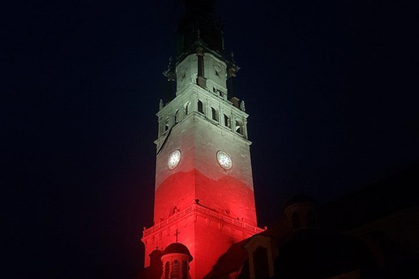 Una torre con dos relojes y un resplandor rojo en la base. 1