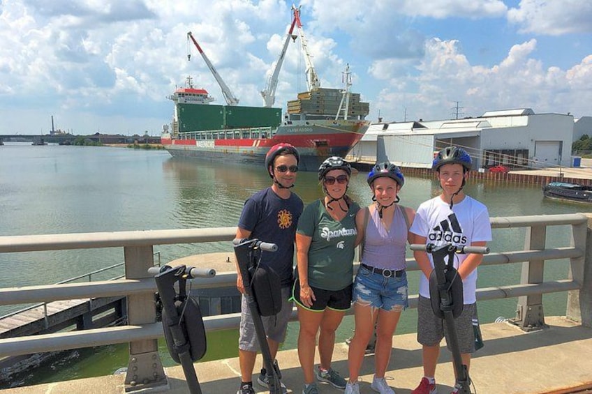 Un grupo de personas en un muelle, con un barco grande al fondo. 3
