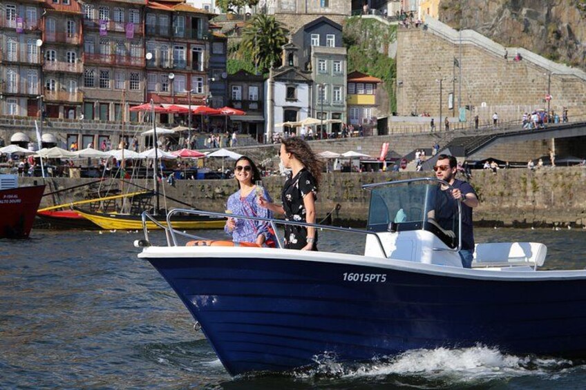 A boat named '16015PT5' on water with people on board and a coastal town in the background. 5