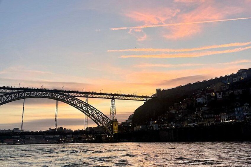 A bridge, a river, and a cityscape at sunset. 3