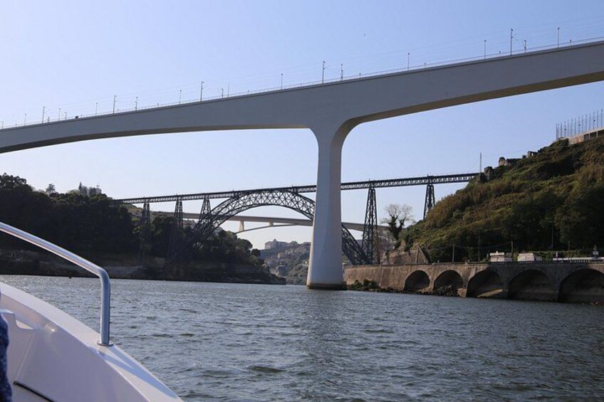 A modern bridge with large white supports and a smaller steel bridge in the background. 4